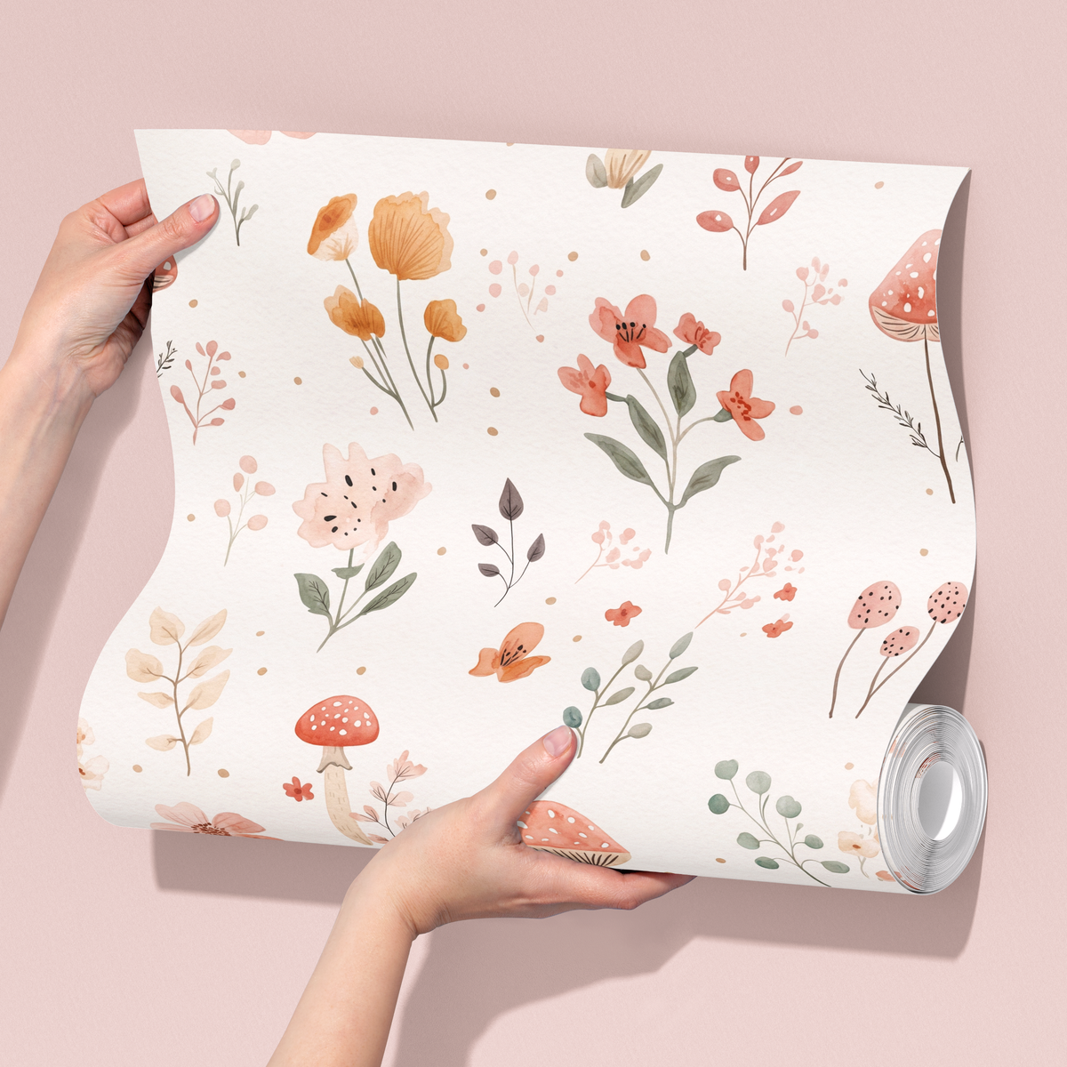 Hands holding a mushroom and wildflower wallpaper sample sheet, showing soft watercolour flowers, woodland mushrooms and leafy botanical details.