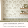 Wallpaper with house and tree pattern, shelves with decor, and text about Petite Playhouse wallpaper.