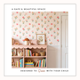 Vintage floral stripe wallpaper styled above children's bookshelf creating a soft botanical nursery wall.