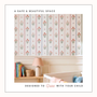 Nursery wall styled with floral stripe wallpaper wooden shelf toys books and warm sunlight.