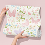 Butterfly floral wallpaper sample held in hands, pastel nursery wallpaper with pink and purple butterflies and delicate flowers