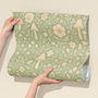 Sage green floral mushroom wallpaper sample held in hands, woodland nursery wallpaper with botanical pattern