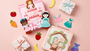 Princess and bear Montessori busy book gift set displayed on a soft pink background, featuring two handmade felt quiet books surrounded by pretend play pieces, dresses, fruit shapes, and wrapped gift boxes, styled as a thoughtful toddler gift for birthdays, holidays, and special occasions.