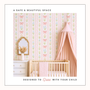Soft pink nursery with bow stripe wallpaper, wooden crib and blush canopy, elegant pastel baby girl bedroom decor