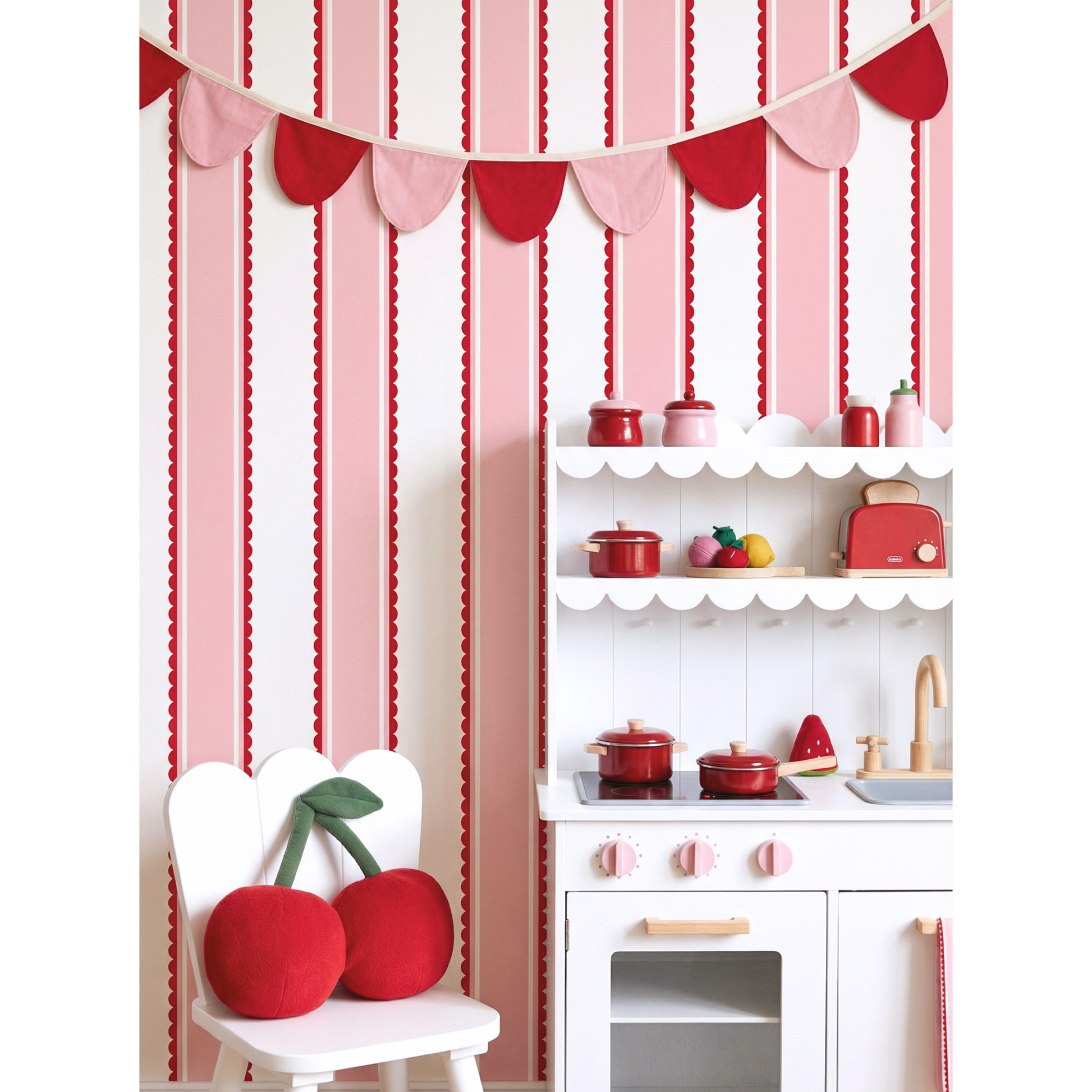 Scalloped stripe wallpaper behind kids play kitchen and chair, red pink striped nursery wall design