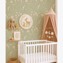 Sage green woodland wallpaper in baby nursery with crib, bunny toy and floral mushroom pattern wall decor