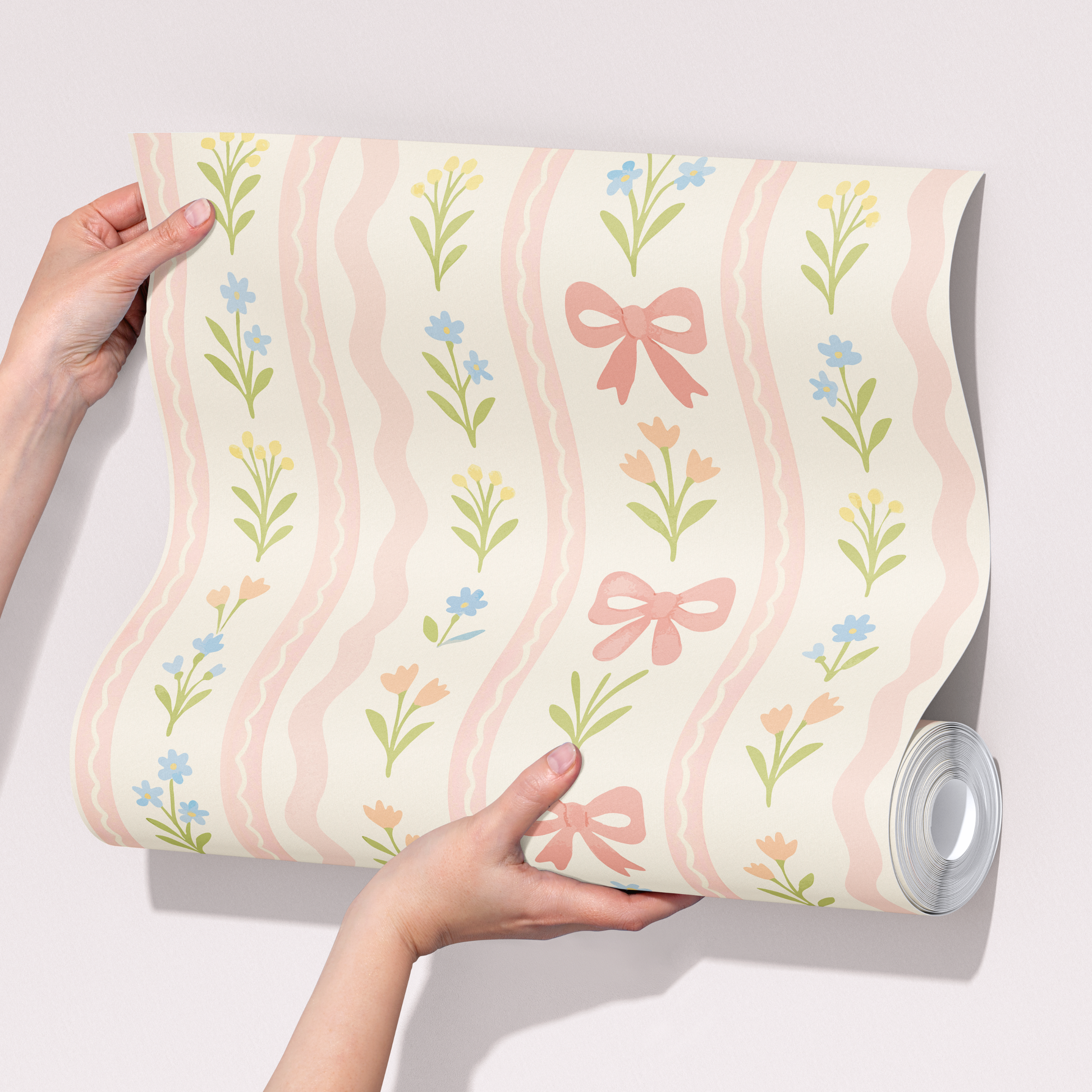 Pink bow floral wallpaper sample held in hands, pastel nursery wallpaper with wavy stripes, flowers and bows, soft coquette girls room decor